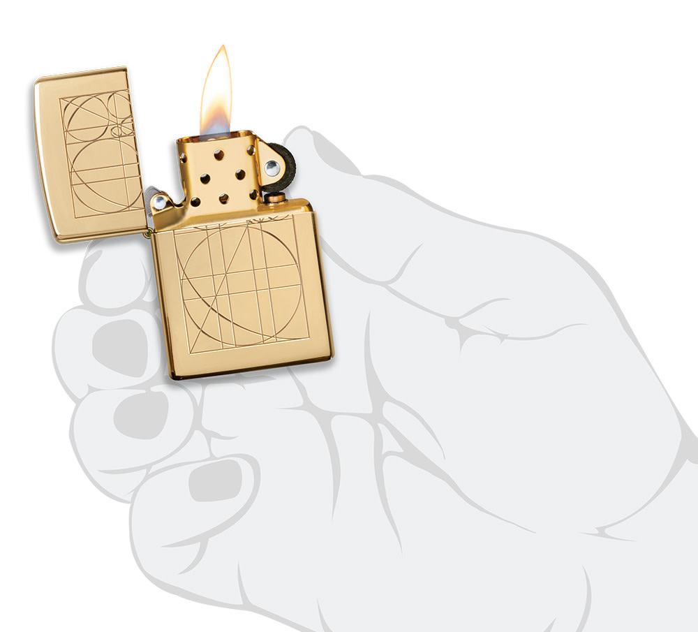 Golden Ratio ArmorÂ® High Polish Brass Windproof Lighter lit in hand